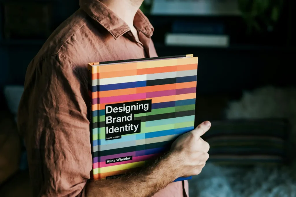 Pessoa segurando um livro sobre identidade de marca com destaque para diferenciação de marca, destacando estratégias de transformar o Sweet Spot em vantagem competitiva.
