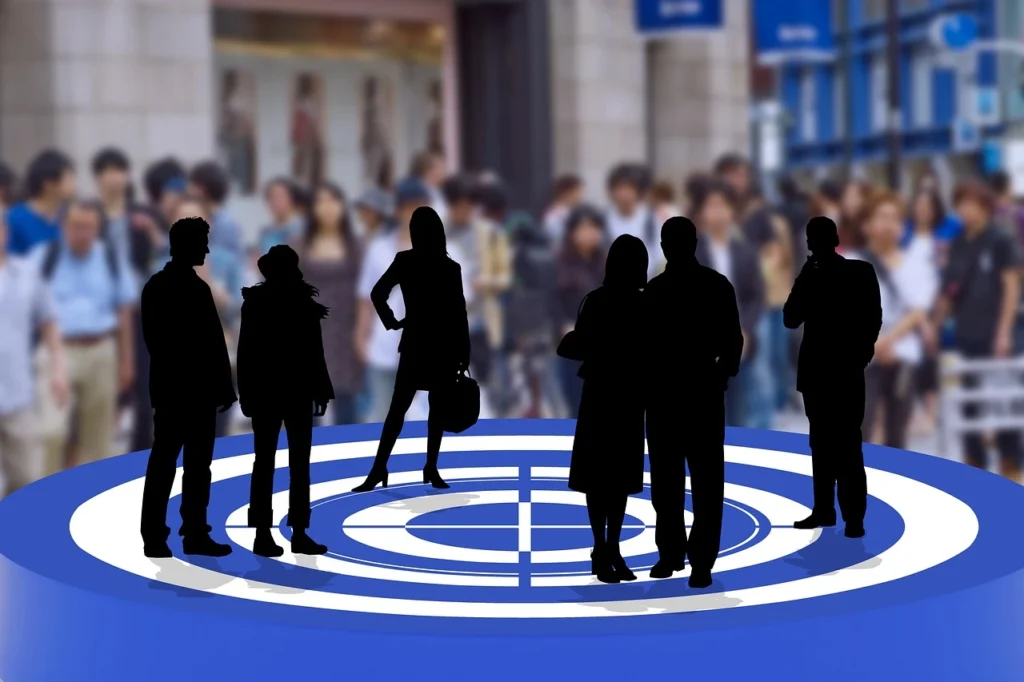 Grupo de pessoas em um cenário de negócios com destaque para silhuetas na frente e uma multidão desfocada ao fundo, relacionado à identificando oportunidades de mercado.